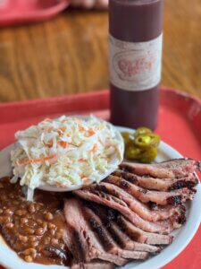Brisket, cole slaw and Stubby's BBQ sauce on a table at our restaurant