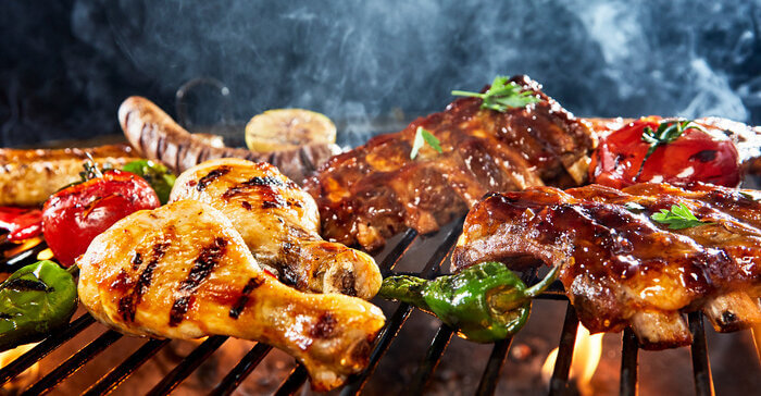 Assorted meat grilling over a BBQ outdoors
